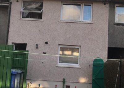 white roughcating on a house with a open window